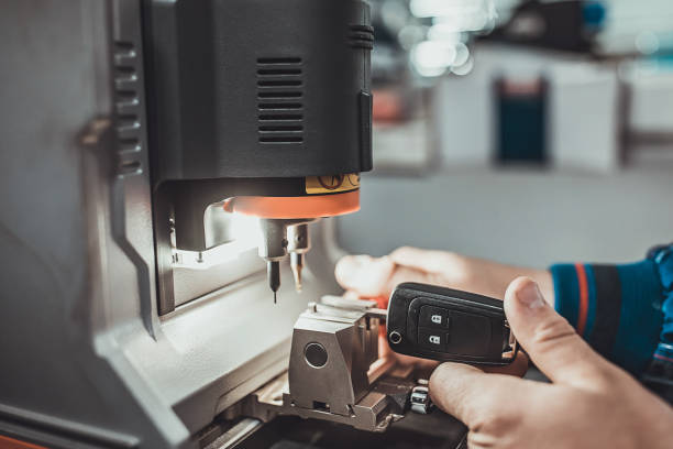 One young man, professional key cutter, making door keys copies in locksmith.