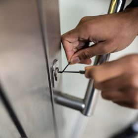 Close-up Of Male Lockpicker Fixing Door Handle At Home