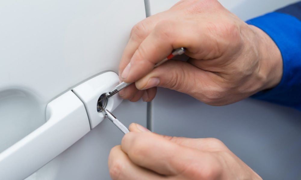 Hand Holding Lockpicker To Open Car Door